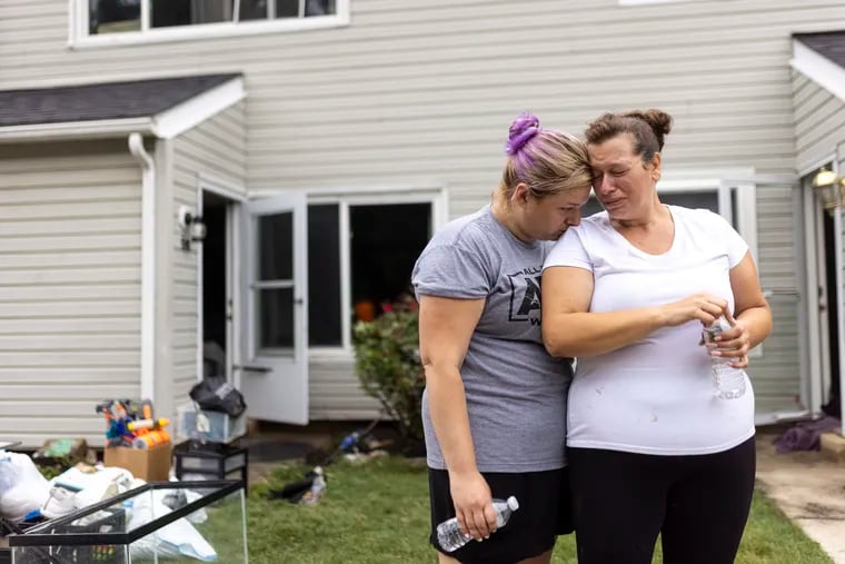 Connie Leon, 39, (right), is comforted by her sister Tiffany Waldron, 34, (left), in front of her home where she lost almost everything inside caused by Monday's flooding at the Lafayette Gardens condominium complex in Bensalem.