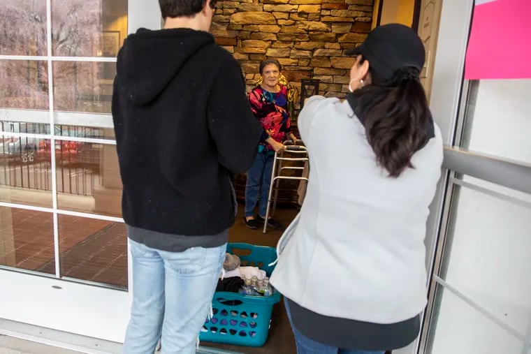Anthony Ciliberto (left), 15, visits his grandmother Yolanda Monterosso, 82, with his mother, Sabrina Ciliberto-Willoughby (right) from outside the doorway of the Phoebe Wyncote retirement community on Monday, March 30, 2020.