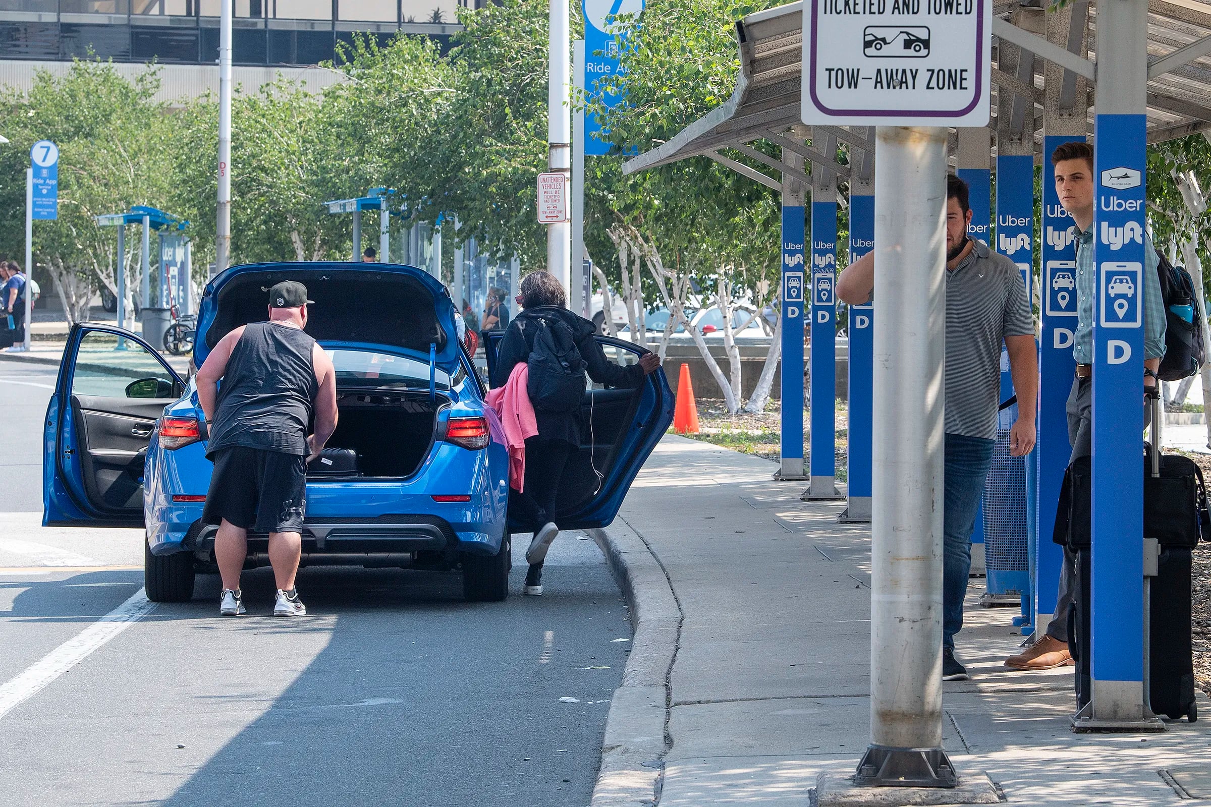 Uber and Lyft drivers picking up arriving passengers outside the baggage claim in July 2021 at the Philadelphia International Airport.