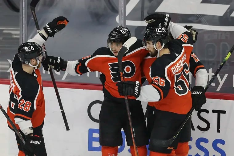 The Flyers' Shayne Gostisbehere (center) celebrates his first-period goal Wednesday against the New York Rangers with Claude Giroux (left) and Erik Gustafsson. Each player had two points in the opening period.