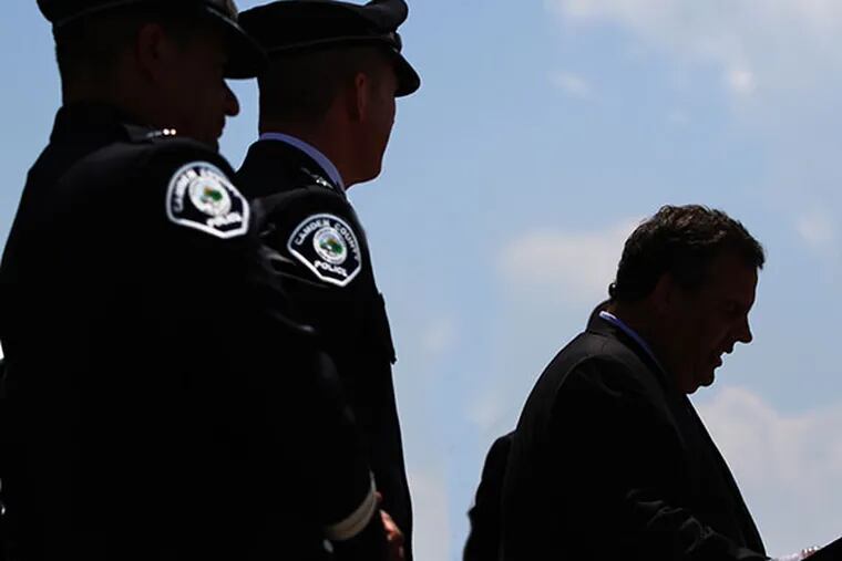 New Jersey Gov. Chris Christie, right, gives a speech praising the work of the Camden County Police Force as some of the Command Staff, left, listen on the stage Tuesday, June 3, 2014, in Camden, N.J. Christie went to Camden to discuss crime statistics and welcome a new class of rookies to the county force. ( Michael Bryant / Staff Photographer )