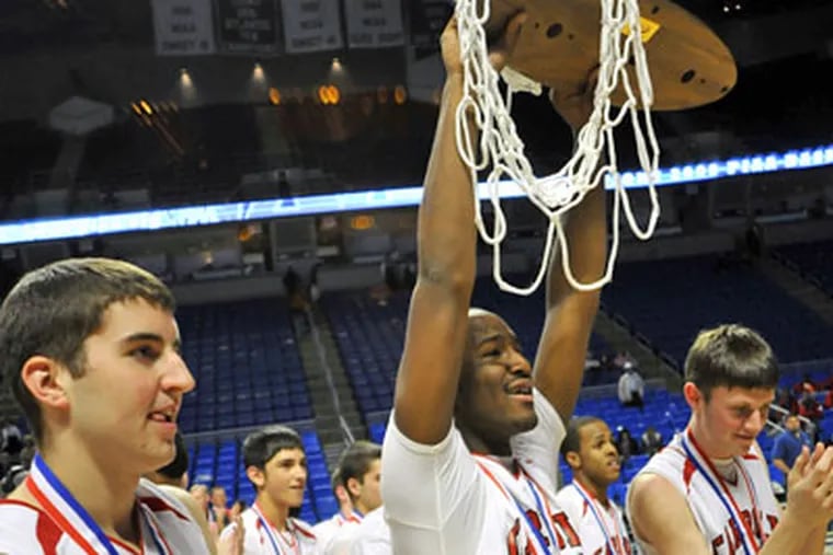 Archbishop Carroll's Andre Wilburn (21) shows the championship trophy to the fans at the end of the PIAA Class AAA boys' state championship basketball game. (AP Photo / Ralph Wilson)