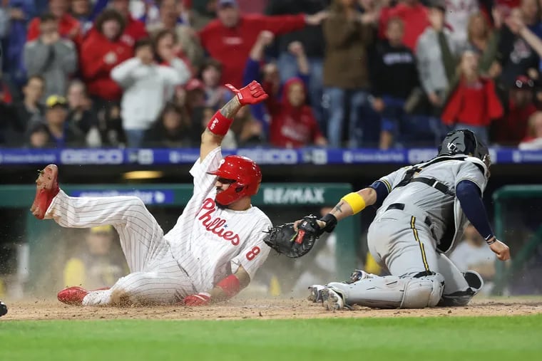 Nick Castellanos, left, of the Phillies scores the go ahead run on a single by Alec Bohm in the 8th inning against the Brewers on April 22, 2022.  Victor Caratini of the Brewers is late with the tag.