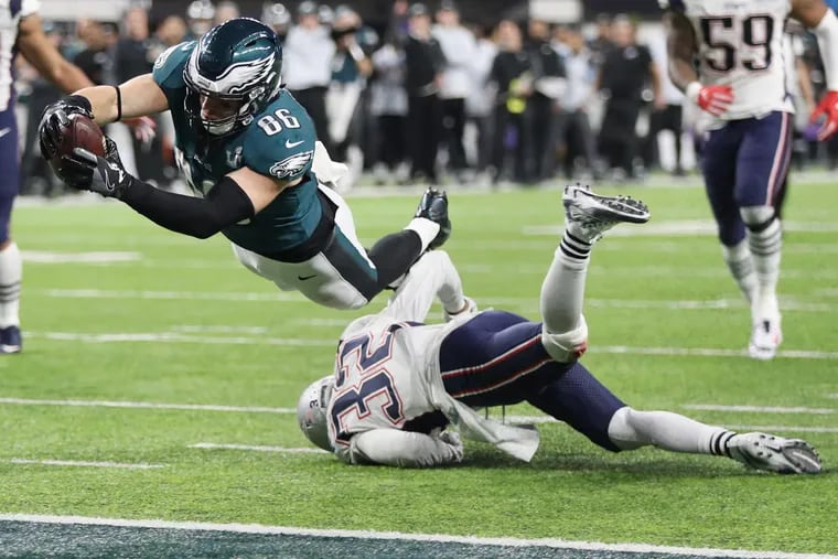 Eagles tight end Zach Ertz dives over New England Patriots defensive back Devin McCourty to score the winning touchdown in the fourth quarter of Super Bowl LII, at U.S. Bank Stadium in Minneapolis, Minnesota, Sunday, Feb. 4, 2018. The Eagles won 41-33. TIM TAI / Staff Photographer