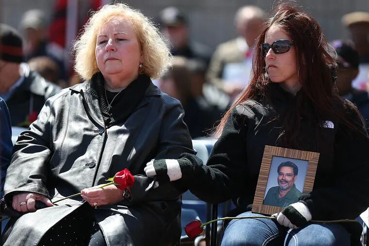 Mary Borger (left), whose husband, James, died while working at the Philadelphia Zoo, is comforted by her daughter Megan at the workers' memorial service. (DAVID MAIALETTI/Staff Photographer)
