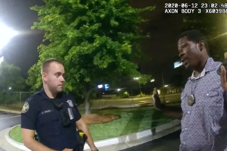 Rayshard Brooks, right, speaks with Officer Garrett Rolfe, left, in the parking lot of a Wendy's restaurant in Atlanta on June 12, 2020.