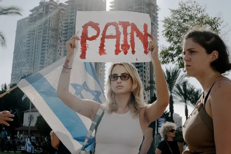An Israeli woman holds a sign that reads "Pain" during an Oct. 14 protest in Tel Aviv for the release of hostages.