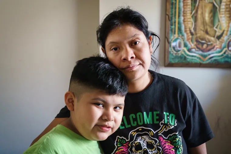 Carmen Palillero hugs her son Daniel Lorenzo, 7. The whole family was sick with COVID-19 in November.