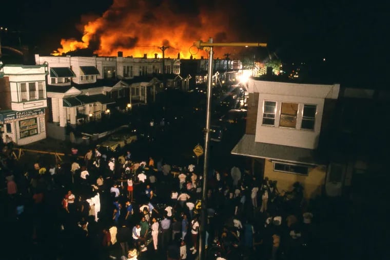 A crowd watches as Osage Avenue erupts in flames, killing 11, during the 1985 MOVE confrontation in West Philadelphia.