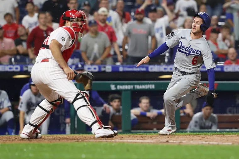 Trea Turner scoring a run for the Dodgers while Phillies catcher J.T. Realmuto awaited the throw in August 2021.