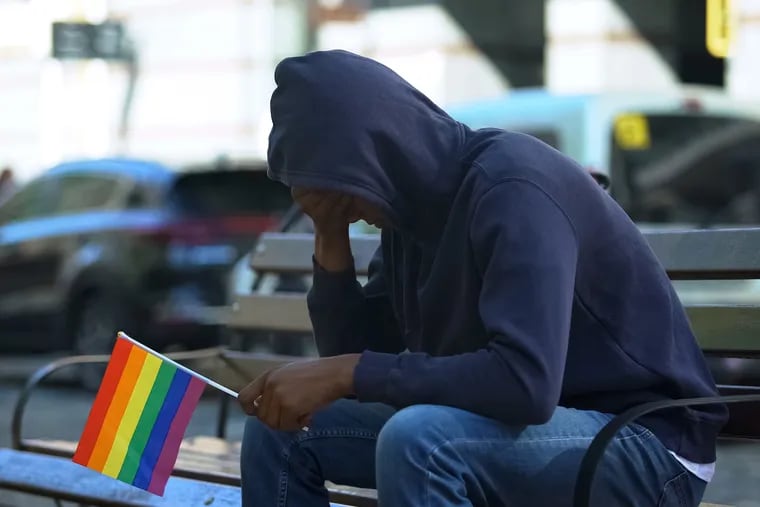 A man sitting on a bench with a rainbow flag. A Florida International University study titled "Anti-LGBTQ Hate Crimes in Miami" found that, in 85% of incidents reported by study participants, crime victims did not report to police what they experienced. Ninety-five percent of victims reported being victimized because of their queer identities.
