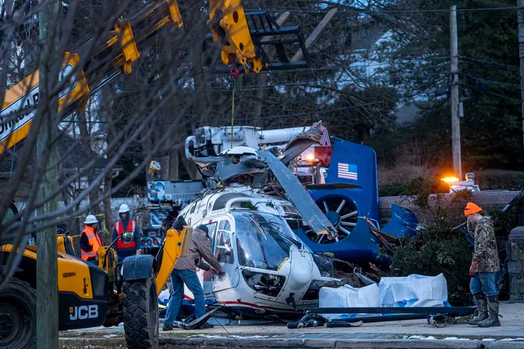 A crashed medical helicopter is removed from the scene in the Drexel Hill section of Upper Darby on Jan. 12, 2022.