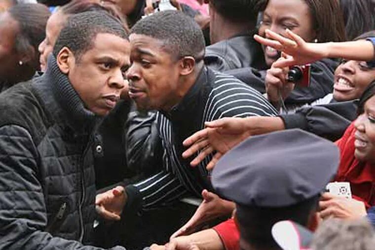 Rapper Jay-Z, left,  greets people at a "Get Out The Vote" Rally on Broad Street in North Philadelphia on Monday. (Jessica Griffin / Staff Photographer)