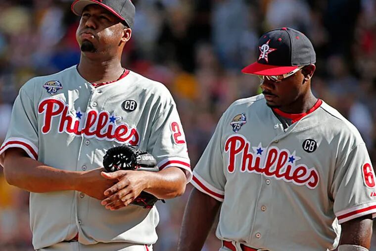 Roberto Hernandez, left, gets a visit from first baseman Ryan Howard (6) during the first inning of a baseball game against the Pittsburgh Pirates in Pittsburgh, Friday, July 4, 2014. (Gene J. Puskar/AP)