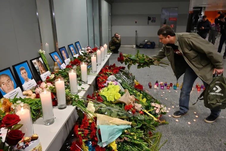 A man places flowers at a memorial for the victims of the Ukraine International Airlines Boeing 737-800 crash in the Iranian capital Tehran, at the Boryspil airport outside Kiev on January 8, 2020. A Ukrainian airliner crashed shortly after take-off from Tehran Wednesday killing all 176 people on board, in a disaster striking a region rattled by heightened military tensions.