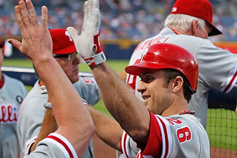 Chase Utley celebrates in the dugout after hitting a home run in the first inning. (John Bazemore/AP)