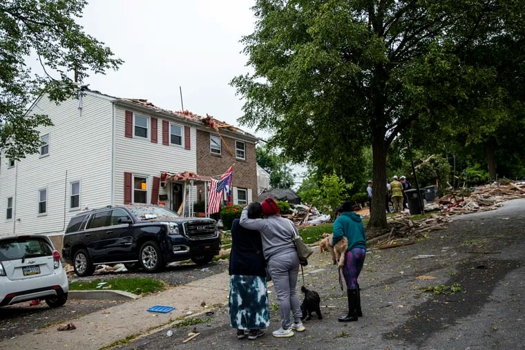People comforting each other as they look at the damages from the house explosion on Hale Street in Pottstown, Pa., where reports of four dead and two missing on Friday, May 27, 2022.