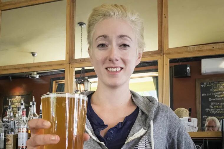 Kathryn Wiggins, brew manager of American Sardine Bar in Point Breeze, with a pint of American Sardine Ale, produced for the bar by Manayunk Brewing Co.