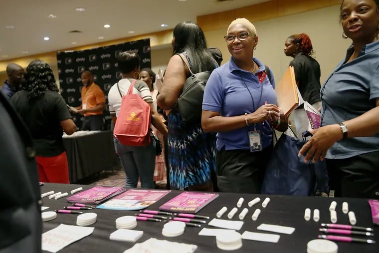 Tammy Smith, a cashier at the cafeteria at Hahnemann, stops by a table during the Hire Hahnemann job fair at the Pennsylvania Convention Center in Center City Philadelphia on Thursday, July 25, 2019. The job fair, which was open to the public, was intended to help Hahnemann University Hospital employees find new jobs after the hospital closes.