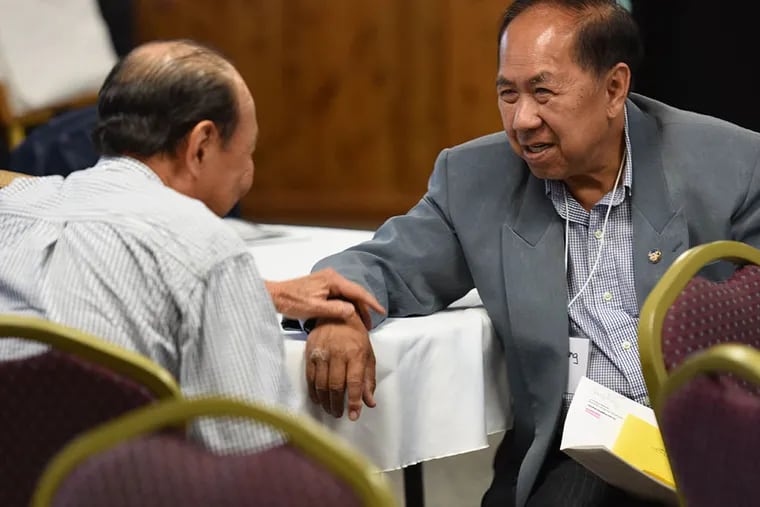 Former South Vietnamese refugees Quy Truong, left, and Duc Huang get reacquainted at their 40th reunion at Fort Indiantown Gap. (Bradley C Bower/For The Inquirer)