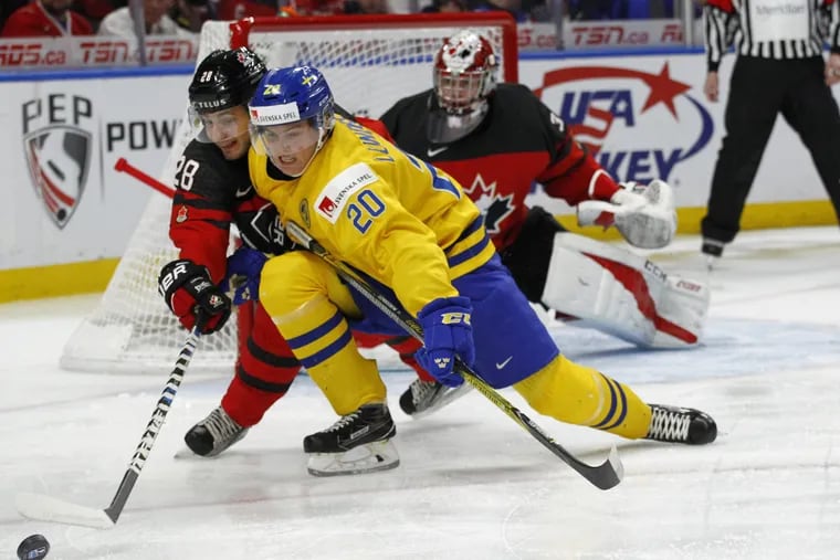 Canada defenseman Victoe Mete (28) and Sweden forward Isac Lundestrom (20) vie for the puck during the title game of the IIHF world junior hockey championships in January. Lundestrom, a center, will be on the Flyers' draft radar this weekend.