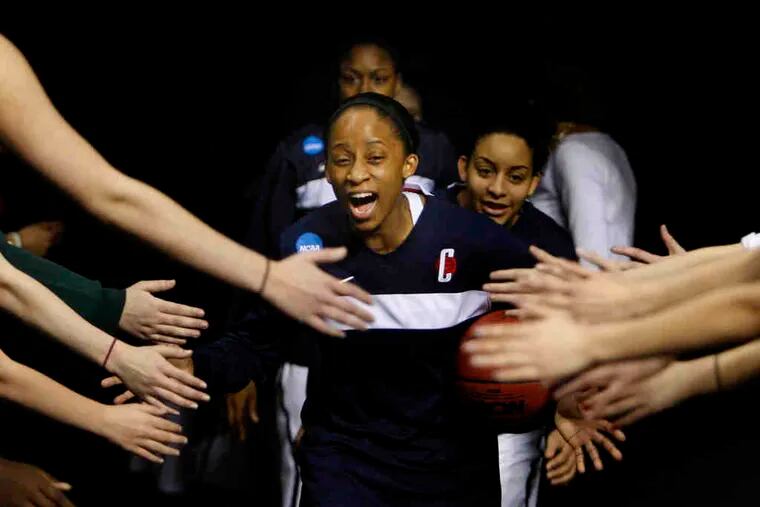 UConn's senior spark plug, Lorin Dixon, leads her team onto the court before Sunday's game.