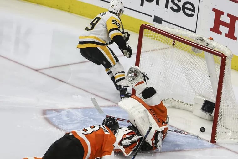 Pittsburgh’s Jake Guentzel scoring one of his four goals in Game 6 as Flyers goalie Michal Neuvirth and defenseman Ivan Provorov go down to the ice Sunday.