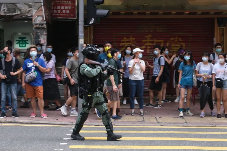 A riot police officer points a tear gas rifle towards demonstrators during a protest in Hong Kong on July 1.