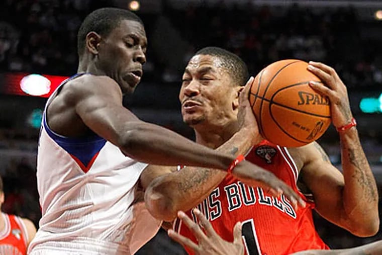 Jrue Holiday stops a drive by Chicago's Derrick Rose during the second half. (Charles Rex Arbogast/AP)