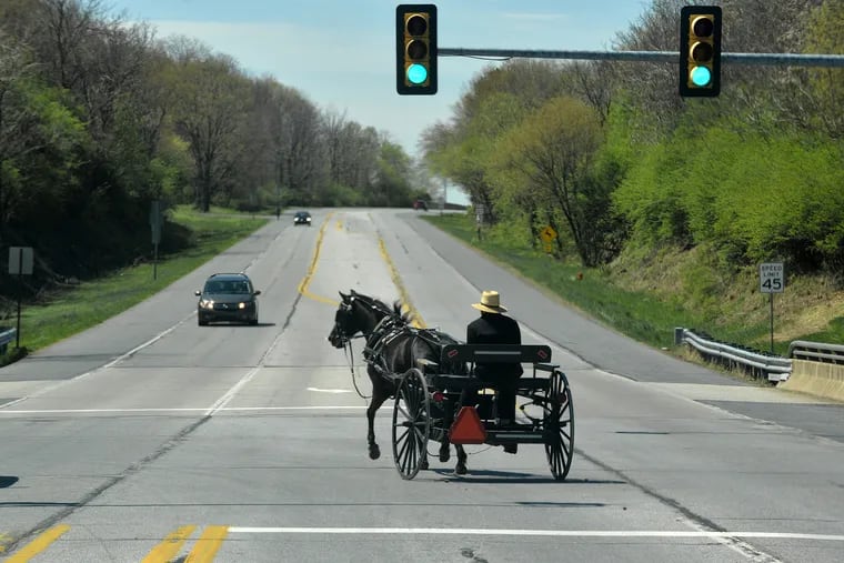 An Amish man drives a buggy on Oregon Pike in Manheim Township, Lancaster County, in April 2019.