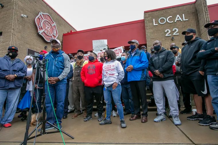 Anthony Hudgins, left at the microphone, and other members of Local 22 of the International Firefighters and Paramedics Union, gather Friday outside their union hall in Philadelphia to protest the union's endorsement of President Donald Trump.