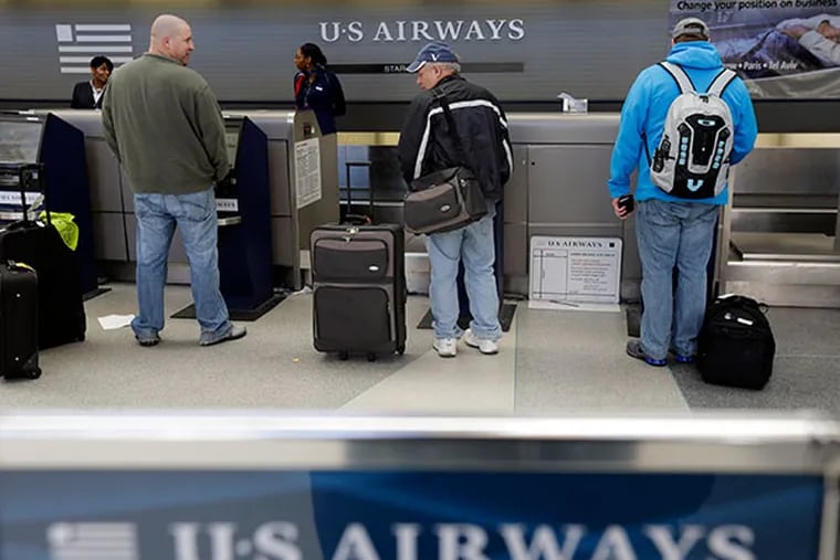 US Airways passengers check in at the ticket counter at Philadelphia International Airport on Feb. 14, 2013, in Philadelphia. (AP File Photo/Matt Rourke)