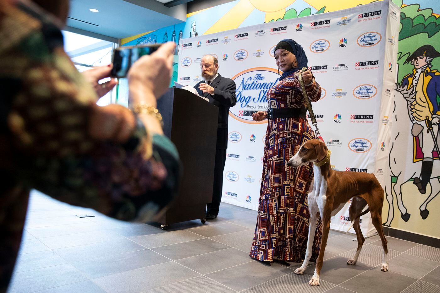 Aliya Taylor shows off Bahir, an Azawakh, as National Dog Show spokesman Steve Griffith speaks during a press event at the Tru Hotel by Hilton in Audobon for the Kennel Club of Philadelphia's National Dog Show.