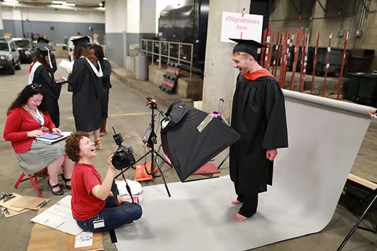 Photographer Elizabeth Manning shows Jacob Bakovsky a photo of his bare feet at the Liacouras Center before graduation ceremonies on Thursday, May 15, 2014. (David Swanson/Staff Photographer)