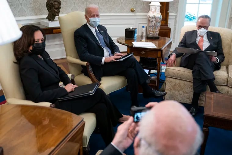 Sen. Patrick Leahy, D-Vt., takes a photo of, from left, Vice President Kamala Harris, President Joe Biden, and Senate Majority Leader Sen. Chuck Schumer of N.Y., during a meeting to discuss a coronavirus relief package, in the Oval Office of the White House on Wednesday.