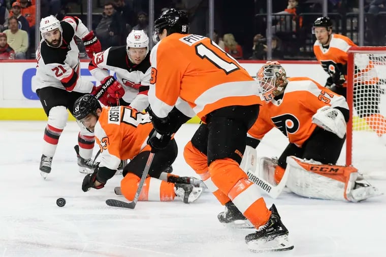 Flyers defenseman Shayne Gostisbehere passed the puck from his knees as goaltender Brian Elliott protected the net against New Jersey last season. The teams will face each other in the first of eight meetings Tuesday.