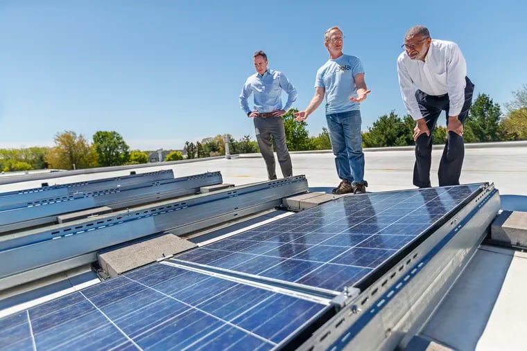 Pennsylvania State Sens. Steve Santarsiero, left, and Art Hawood, right, inspect a rooftop solar installation along with Mark Bortman, the founder of Exact Solar, a Bucks County installer. Santarsiero and Haywood, along with State Sen. Tom Killion, are sponsoring a bill to increase renewable power incentives in Pennsylvania.