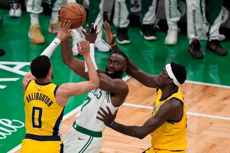 Celtics guard Jaylen Brown passes the ball under pressure from Pacers guard Tyrese Haliburton and forward Pascal Siakam during Game 1 of the Eastern Conference finals on Tuesday.