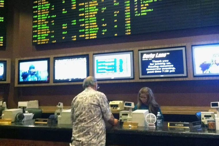 A football fan places his bets in the sports book at Harrah’s Las Vegas Resort Hotel. New Jersey is hoping to win approval for sports betting, now limited to four other states. (SUZETTE PARMLEY/Inquirer Staff)