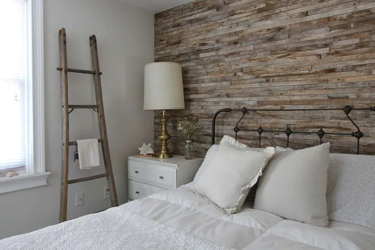 In this bedroom, the accent wall is covered with lath, unfinished wood strips.