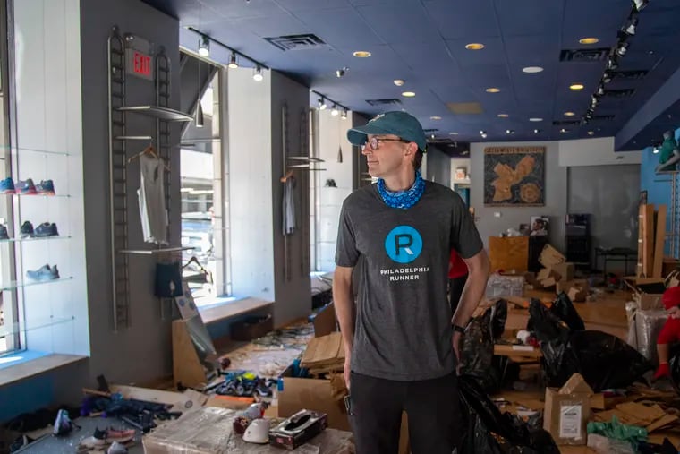 Ross Martinson owner of the Philadelphia Runner shop at 1601 Sansom Street, looks around his damaged store on May 31, 2020 as the clean up began the day after the  George Floyd protests occurred in Philadelphia, Pa. .