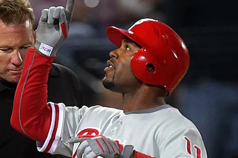 Jimmy Rollins crosses home after hitting a grand slam in the sixth inning. (AP Photo/John Bazemore)