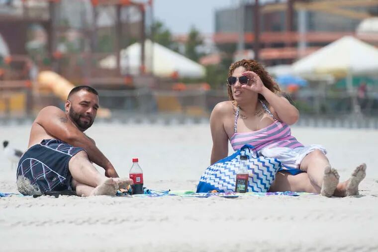 PHOTOS: MICHAEL PRONZATO / STAFF PHOTOGRAPHERThey're so shore! Another tough day at the beach in Wildwood yesterday. A group of young guys got together to work on their Wiffle Ball skills (left) while Jose Heredia and Soraya Cardona (above) take a break from relaxing.