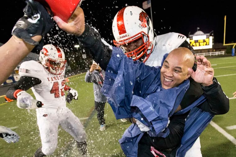 Imhotep head coach Albie Crosby gets the requisite victory shower in the final minutes of the Panthers' 40-3 victory over Erie Cathedral Prep in the Class 3A state championship game Dec. 19. Crosby was named state 3A coach of the year by Pa. football writers.