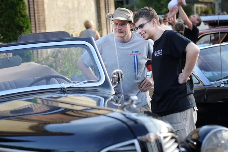 Harold Perrong (left) and Andrew Perrong of Huntingdon Valley, Pennsylvania view a 1939 Dodge during the 6th Annual Doylestown at Dusk Car Show Saturday July 18, 2015 in Doylestown, Pennsylvania