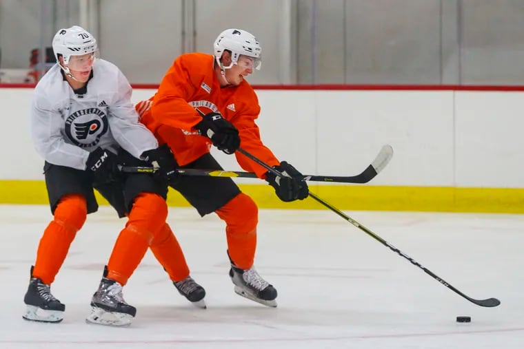 Flyers Isaac Ratcliff, right, fights through the defense of Olle Lyksell, left, on the way to the net during a 3 on 3 game at the Flyers Skate Zone on July 2, 2018.