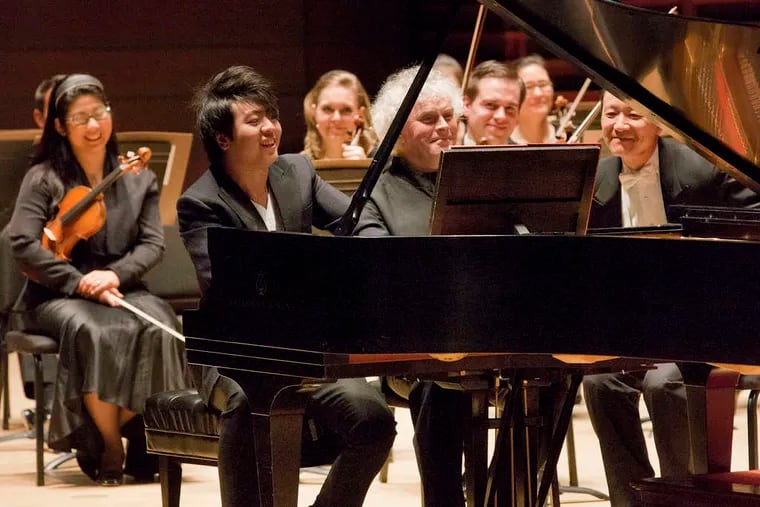 Lang Lang (left) and Simon Rattle perform a piano-duet encore - to uproarious applause.