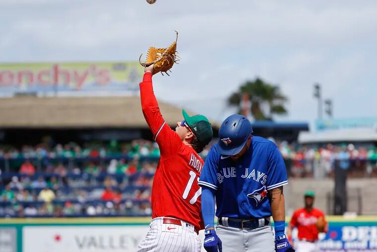 Phillies first baseman Rhys Hoskins watches the baseball into his glove on Blue Jays Rainer Nunez’s pop-up as Nathan Lukes moves away.
