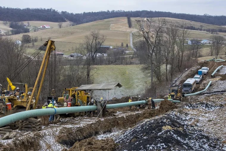 Workers install 20-inch epoxy-coated pipes on the Mariner East 2 pipeline in the rolling hills of Washington County, Pa., February 16, 2017. They can lay 2,000 to 3,000 feet per day.