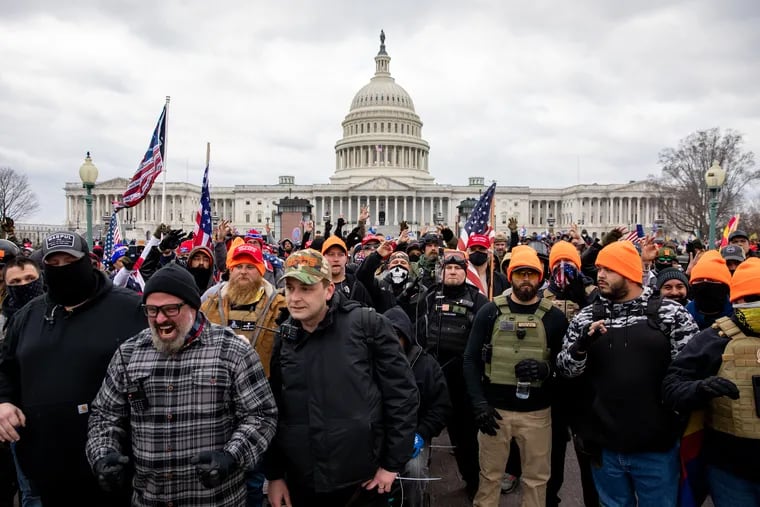 Philly Proud Boys President Zach Rehl (center, in camouflage hat) and Joseph Biggs, a leader of the group from Florida (left, in gray plaid shirt) at the forefront of a crowd of members of the organization that marched on the U.S. Capitol in Washington, D.C., on Jan. 6.